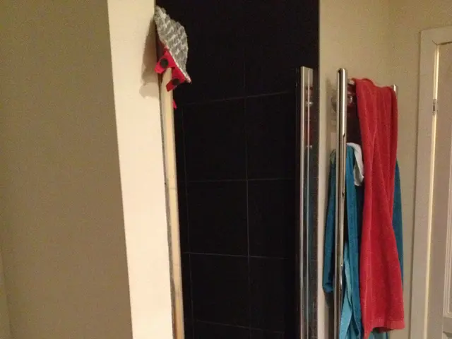 There are two towels which are red and blue in color are placed on a rod and there is a door in the...