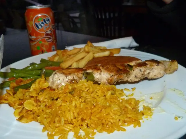 This image consists of food in a plate. We can see the rice, flesh along with french fries. And...